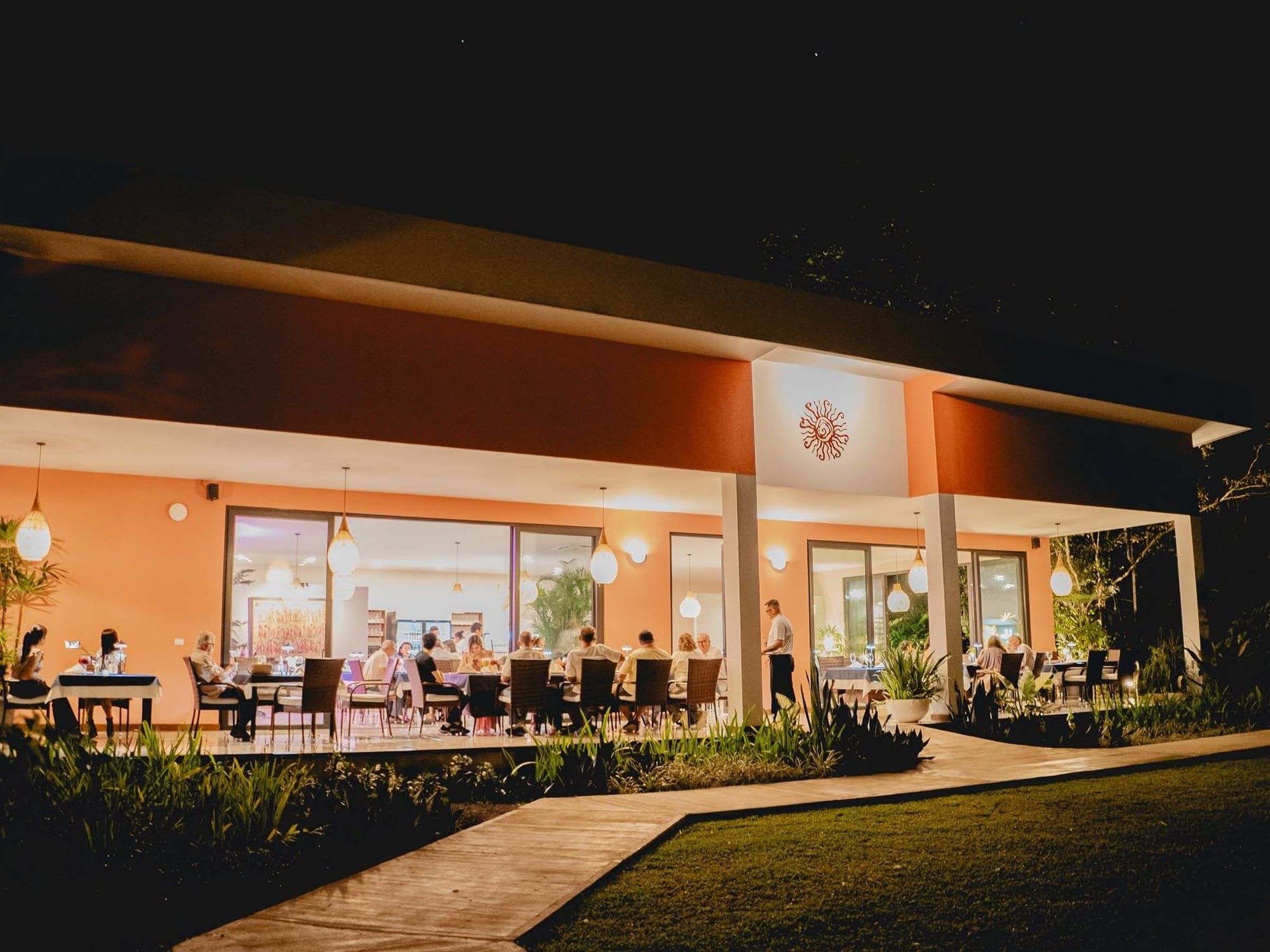 Cena en la terraza iluminada de Yan's Bistro por la noche en Horquetas de Sarapiquí, Ruta 4