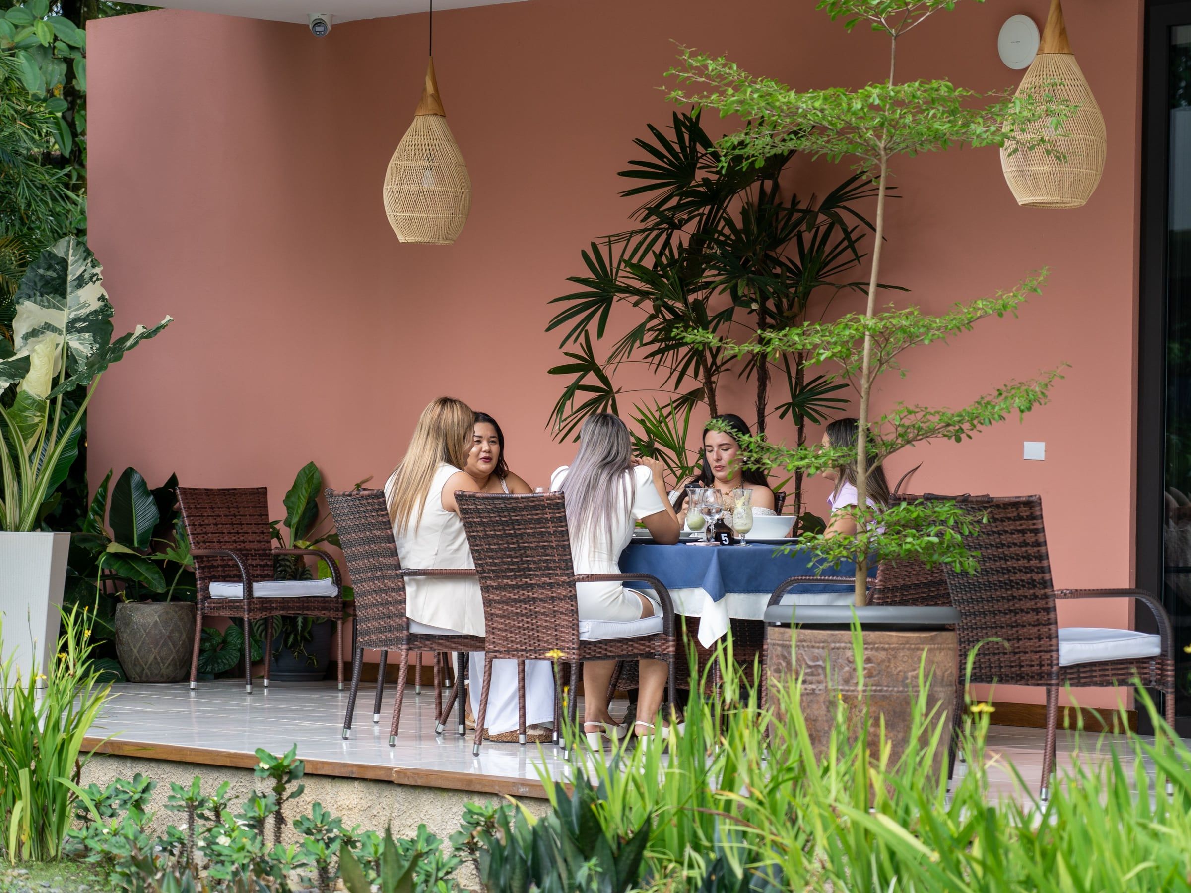 Grupo compartiendo en la terraza de Yan's Bistro entre plantas tropicales, Horquetas de Sarapiquí