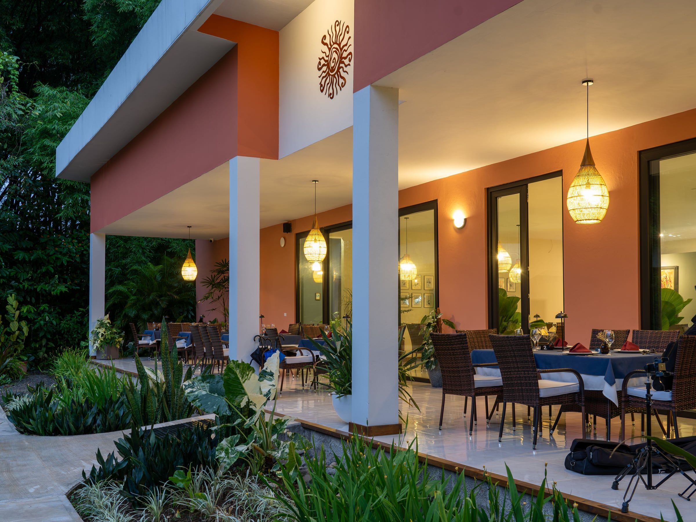 Terraza de Yan's Bistro al atardecer con lámparas cálidas, sobre la Ruta 4 en Horquetas de Sarapiquí